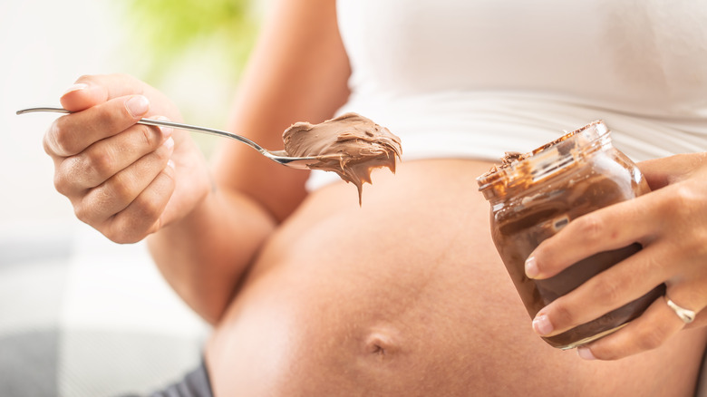 Pregnant woman eating peanut butter