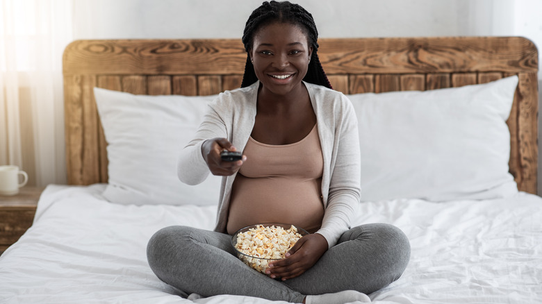 Pregnant woman eating popcorn