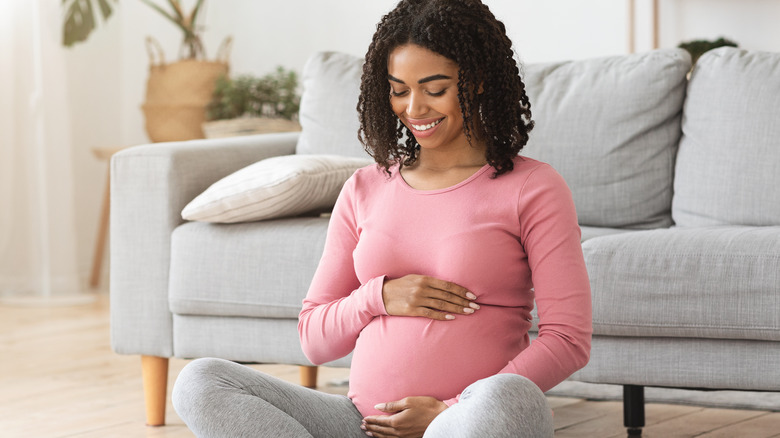 pregnant woman cradling baby bump