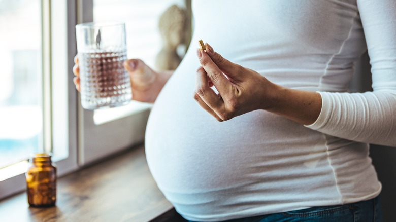 pregnant woman holding pill