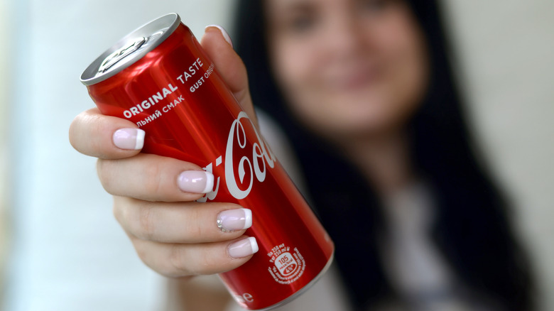 Woman holding can of coca-cola