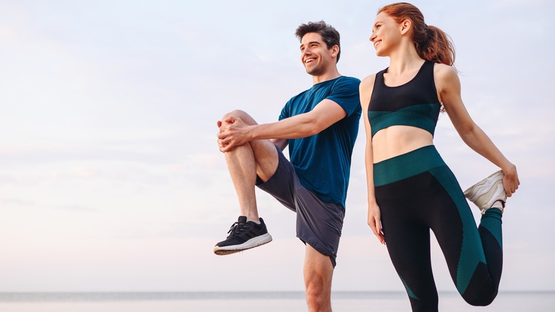 man and woman stretching before exercise