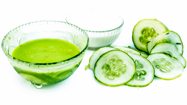 Sliced cucumbers next to bowls