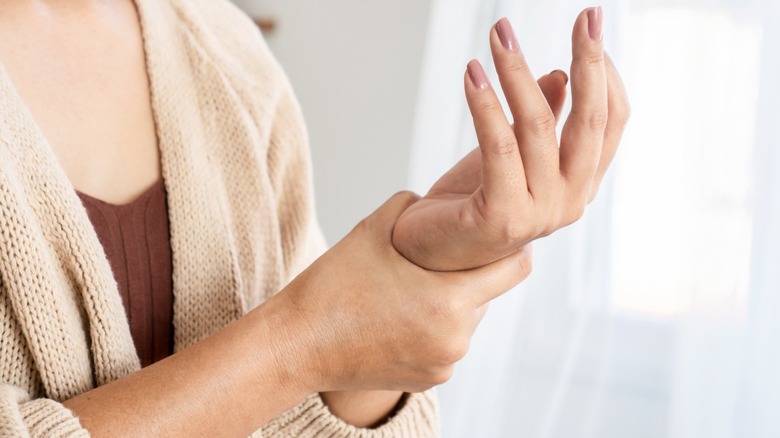 Woman holds her wrist in pain