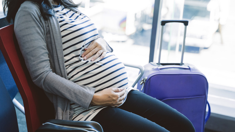 pregnant woman sitting in the airport 