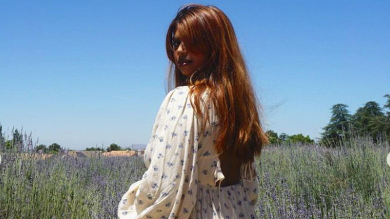 red-headed woman posing in flower field