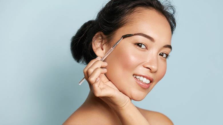 Woman brushing her eyebrow
