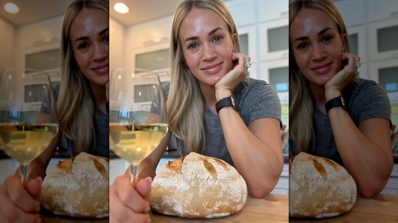 Carrie Underwood smiling with a loaf of bread and glass of wine.