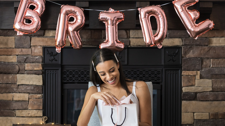 Woman opens gift at a bridal shower