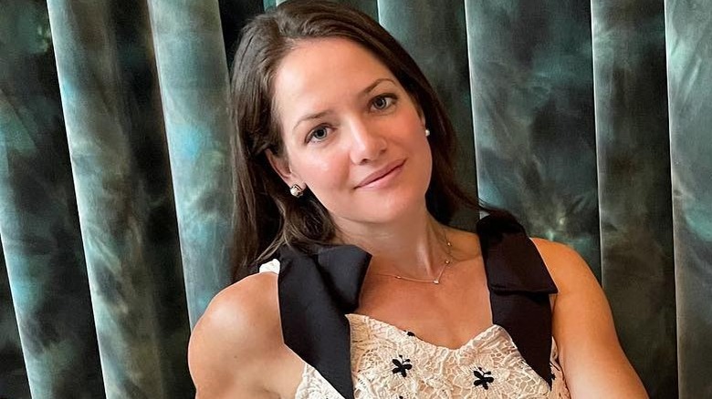 Kate Stotlz posing on couch in dress