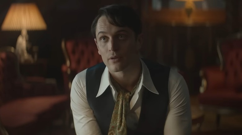 Colin Woodell in a vest and ascot in The Continental