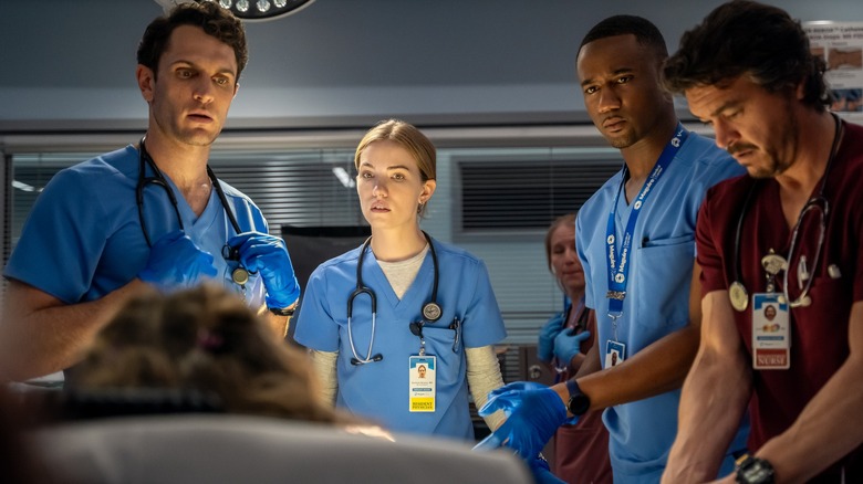 Colin Woodell, Willa Fitzgerald, Jessie T. Usher, Arturo Del Puerto standing around a patient on Pulse