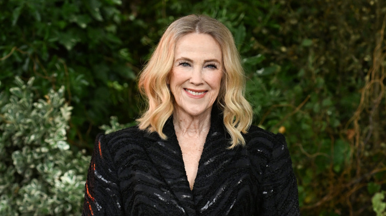 Catherine O'Hara standing outside in a black dress