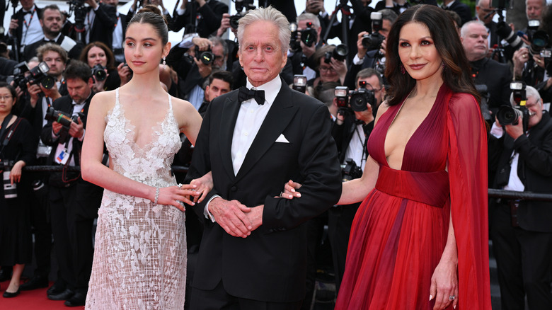 Catherine Zeta-Jones and Carys Zeta Douglas linking arms with Michael Douglas on the Cannes red carpet.
