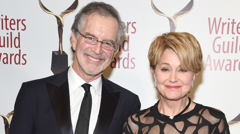 Jane Pauley wearing a black dress with sheer cutouts and husband Garry Trudeau wearing a black suit and tie at the Writers Guild Awards ceremony.