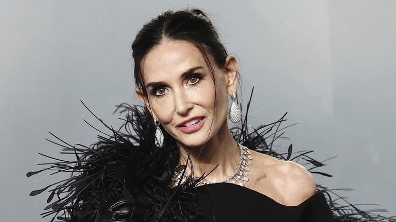 Demi Moore arriving at the 2026 Oscar Vanity Fair afterparty in a black feathery outfit