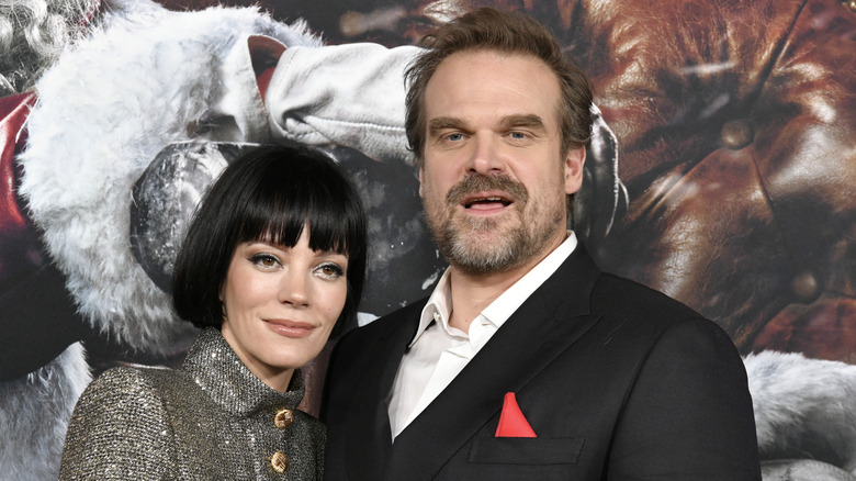 Lily Allen standing close to David Harbour on the red carpet, each looking a slightly different direction.