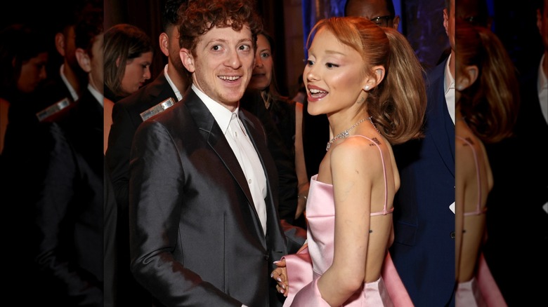 Ethan Slater and Ariana Grande facing each other but looking in different directions