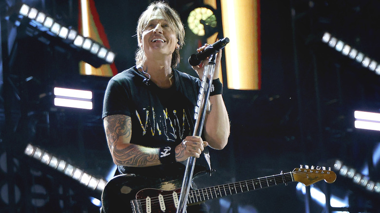 Keith Urban holding mike stand during Nashville show 2025
