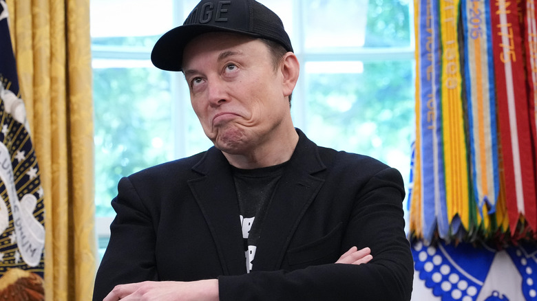 Elon Musk grimacing in Oval Office
