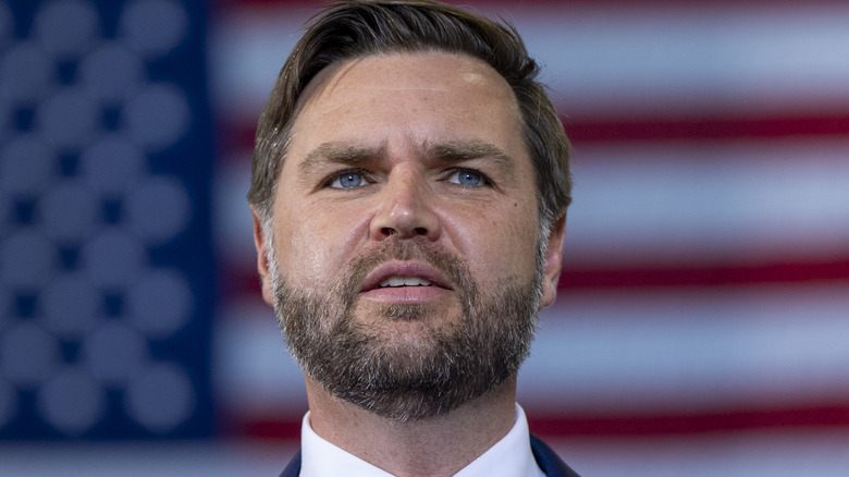 JD Vance in front of flag looking off