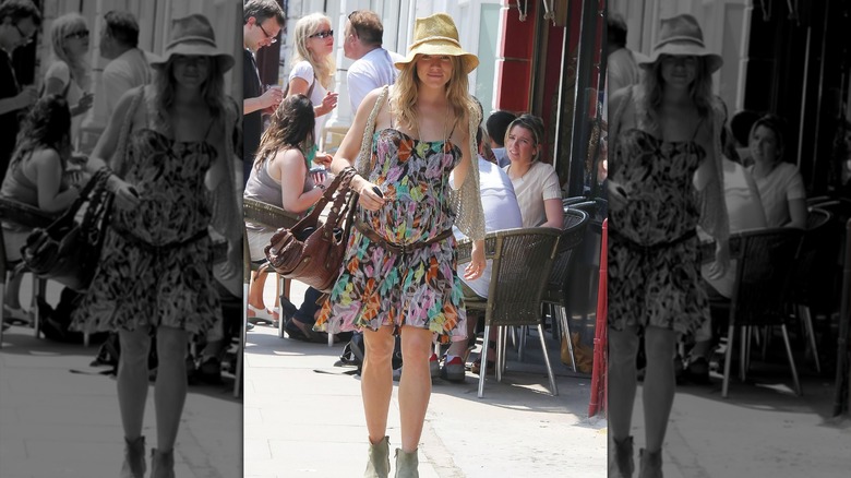 Sienna Miller walking around London in a colorful floral dress while pregnant