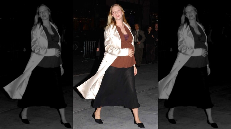 Pregnant Uma Thurman in a brown top and black skirt