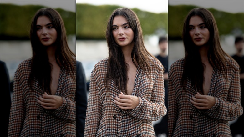 Deva Cassel smiling in a checked jacket