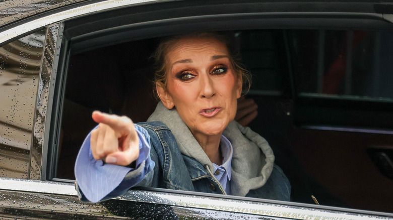 Céline Dion pointing out of a car in Paris in 2024
