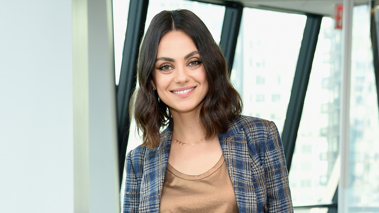 Mila Kunis poses at an event