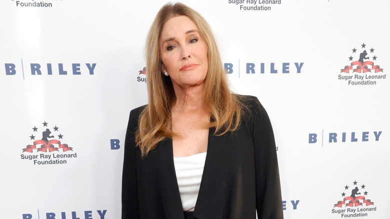 Caitlyn Jenner posing for photos in a black blazer and white top underneath
