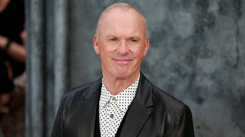 Michael Keaton smiling at a 2024 premiere event for Beetlejuice Beetlejuice.