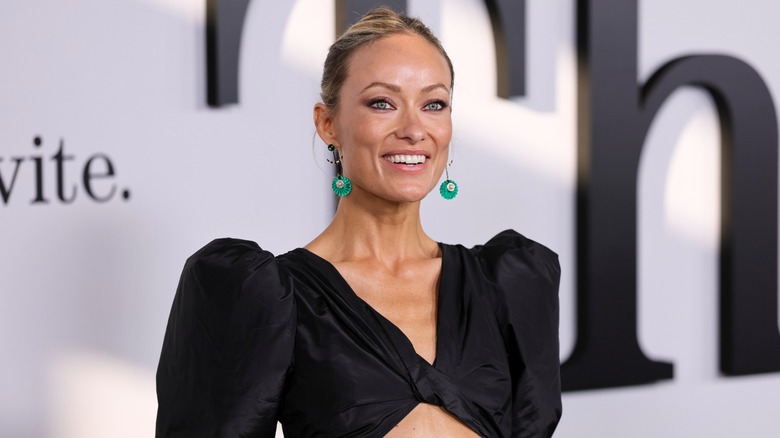 Olivia Wilde smiling at a premiere event for her film The Invite in 2026.