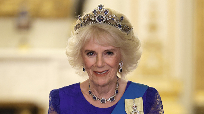 Queen Camilla smiling in a sapphire crown 