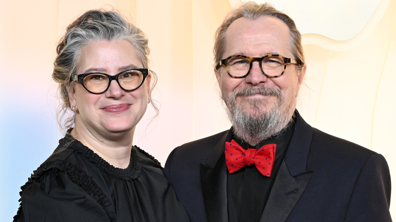 Gisele Schmidt and Gary Oldman smiling and posing on the red carpet
