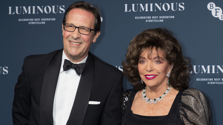 Percy Gibson and Joan Collins posing on the red carpet