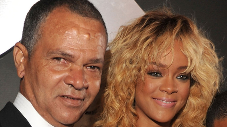 Ronald Fenty posing with daughter Rihanna at a music event