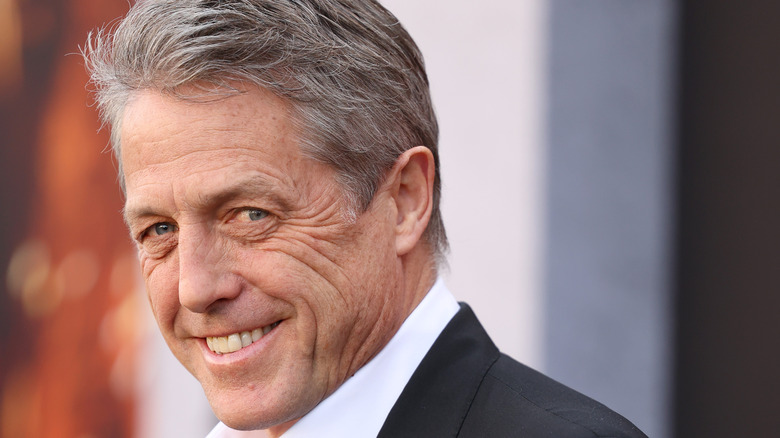 Hugh Grant smiling on red carpet