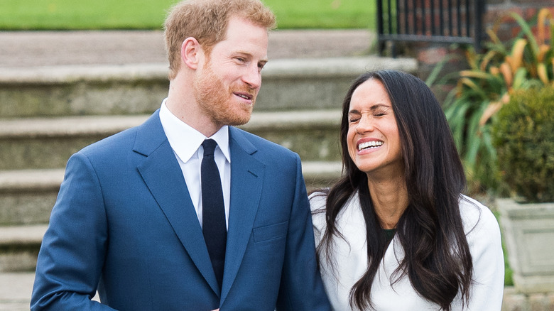 Prince Harry and Meghan Markle laughing outdoors in engagement photo