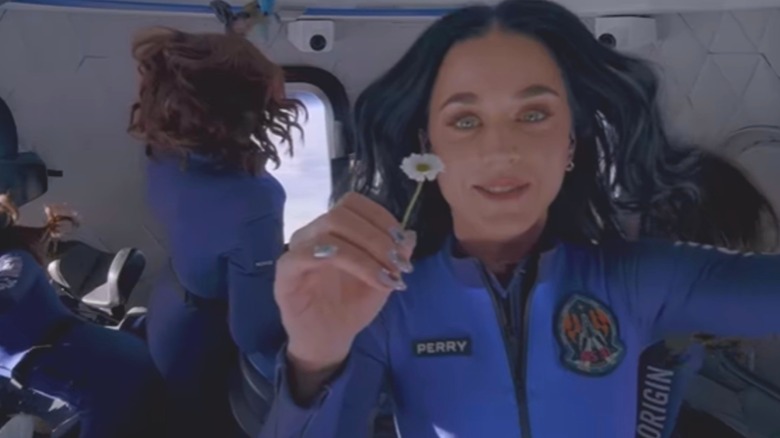 Katy Perry holding a flower in space
