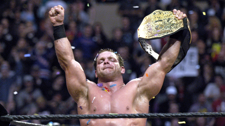 Chris Benoit celebrating with his wrestling championship belt
