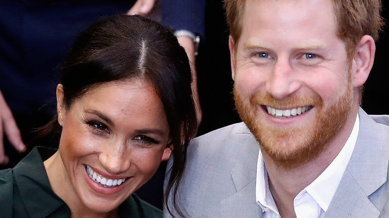 Prince Harry and Meghan Markle smile for a photo. 