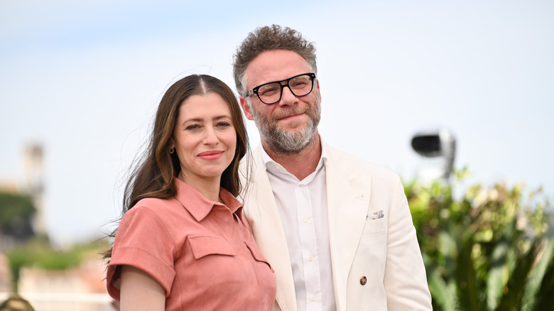 Seth Rogen in white beside Lauren Miller Rogen wearing pink