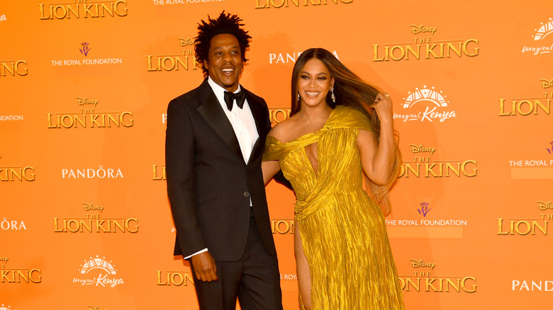 Jay-Z in a tux with Beyonce in gold off the shoulder gown at Lion King premier
