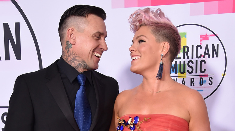 Pink with pink hair in strapless coral dress with Carey Hart in black suit and blue tie