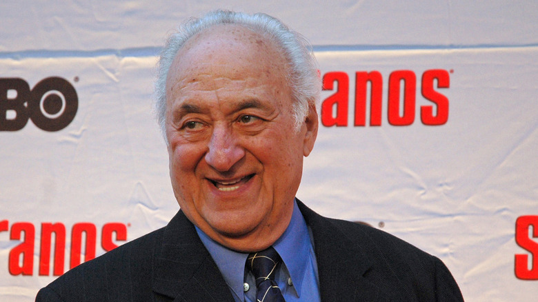 Jerry Adler posing in front of a Sopranos logo backdrop