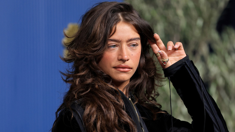 Odessa A'zion touching her hair.