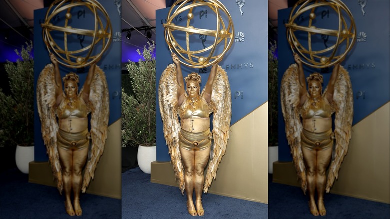 Meg Stalter posing in an Emmy costume.