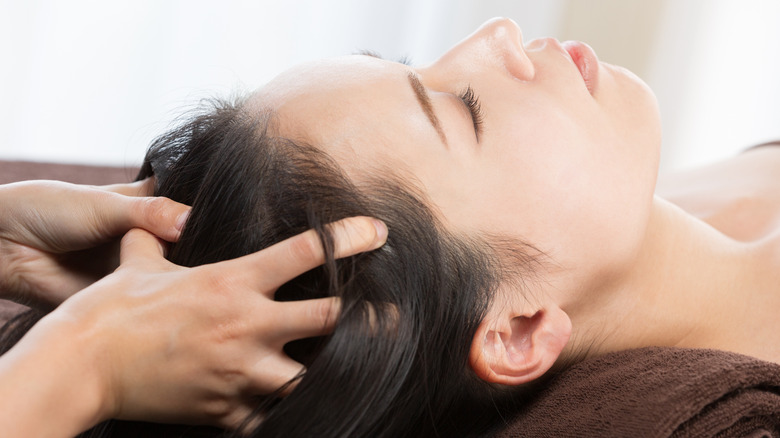 A woman getting a scalp massage 