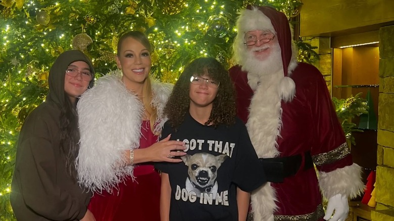 Monroe Cannon, Mariah Carey, and Moroccan Cannon smiling with a man dressed as Santa